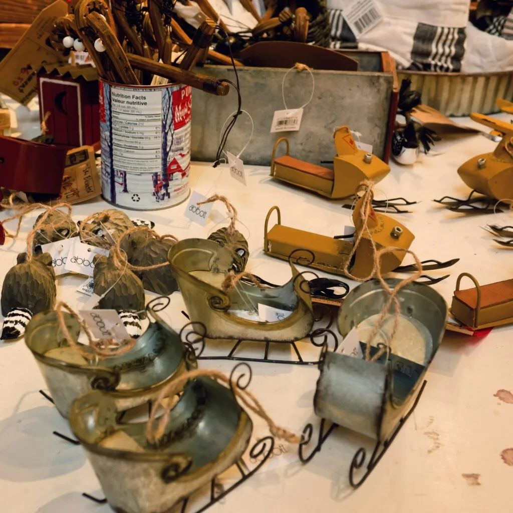 Handmade decorations and small sled ornaments displayed on a craft market table